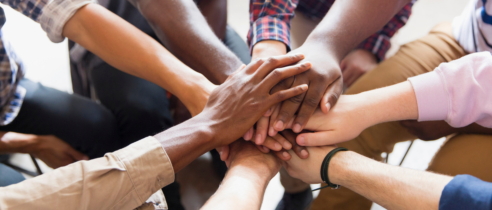 Men joining hands in group therapy.